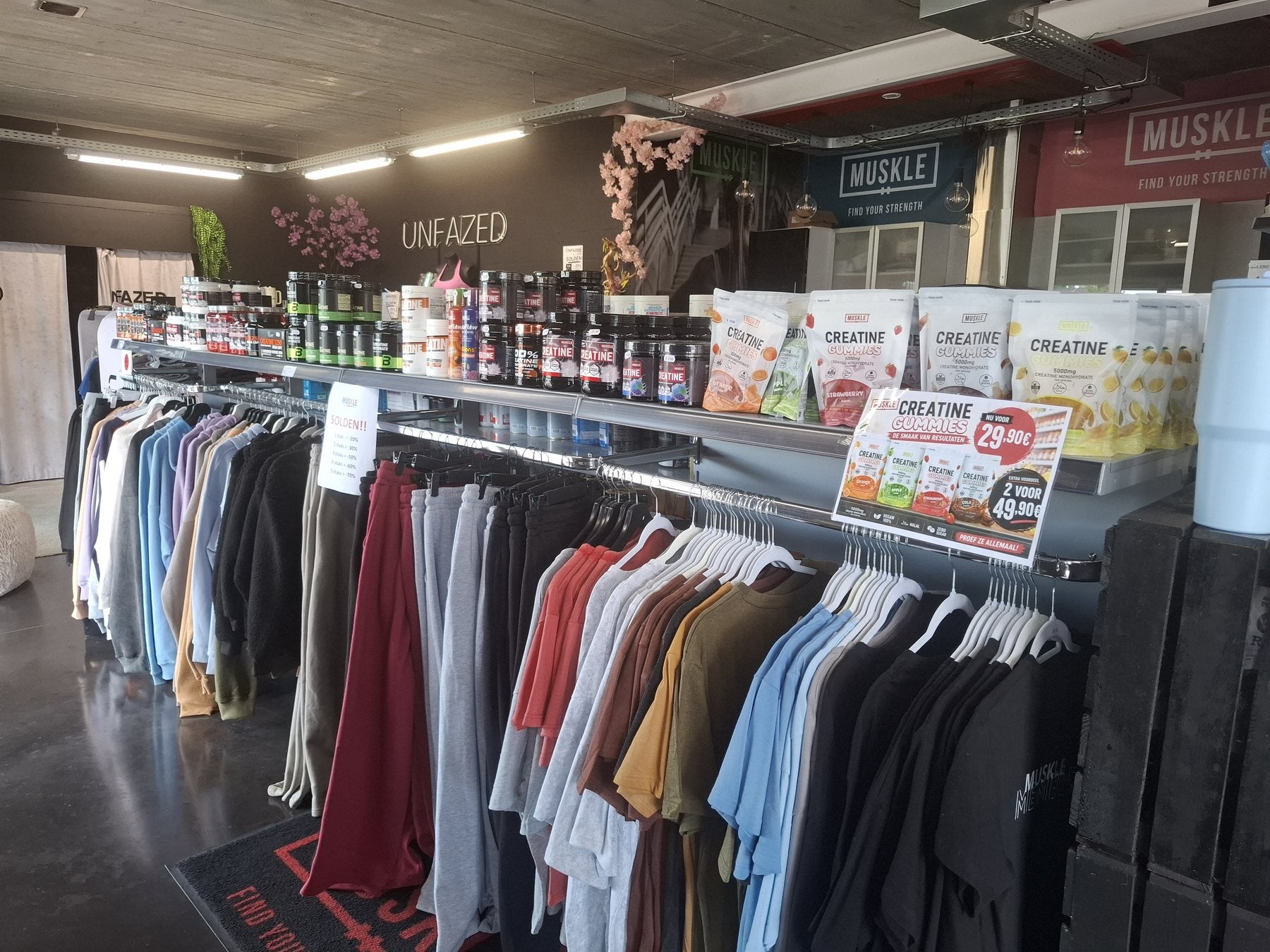 Creatineproducten naast trainingskleding in MUSKLE Bonheiden