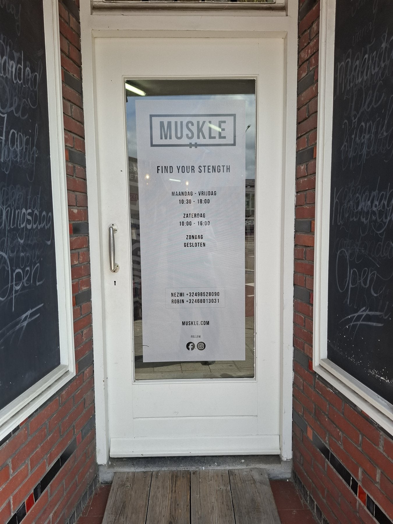 Entrance door of MUSKLE Roosendaal with opening-hours poster
